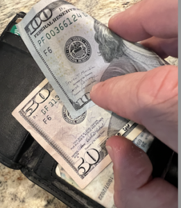 Money coming out of a wallet, for lost wages from a dog bite 